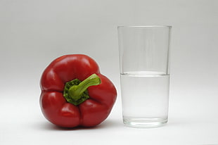 red bell pepper beside drinking glass filled with water HD wallpaper